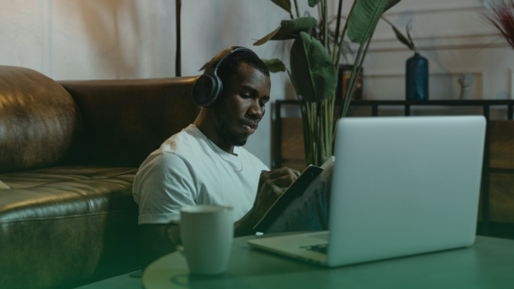 Homem Lendo com notebook na frente e caneca.
