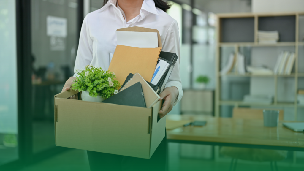mulher carrrregando sua caixa de pertences após a sua demissão. 